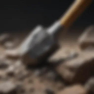 Close-up of a rock hammer striking a rock, with fragments scattering